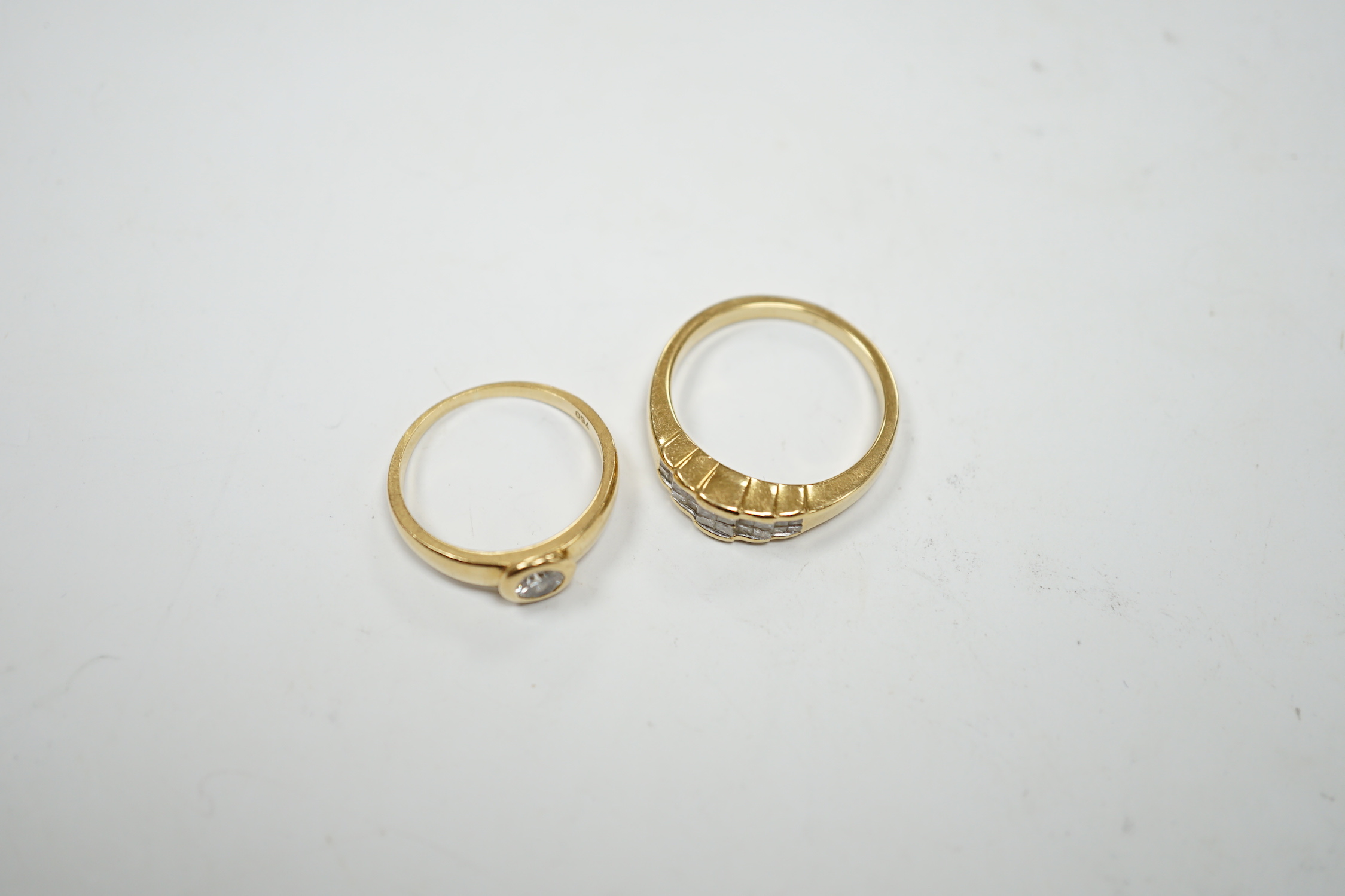 A 750 yellow metal and collet set solitaire diamond ring, size L and a yellow metal and diamond cluster set half hoop ring, size O, gross weight 7.4 grams